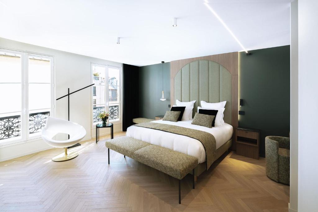 a bedroom with a large bed and a chair at La Source Exclusive Apartment in Paris