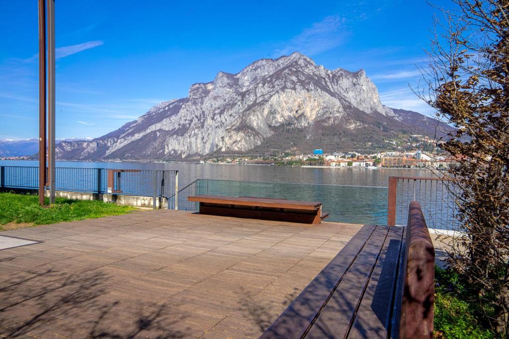 a bench on a dock with a mountain in the background at Casa di Gio in Malgrate