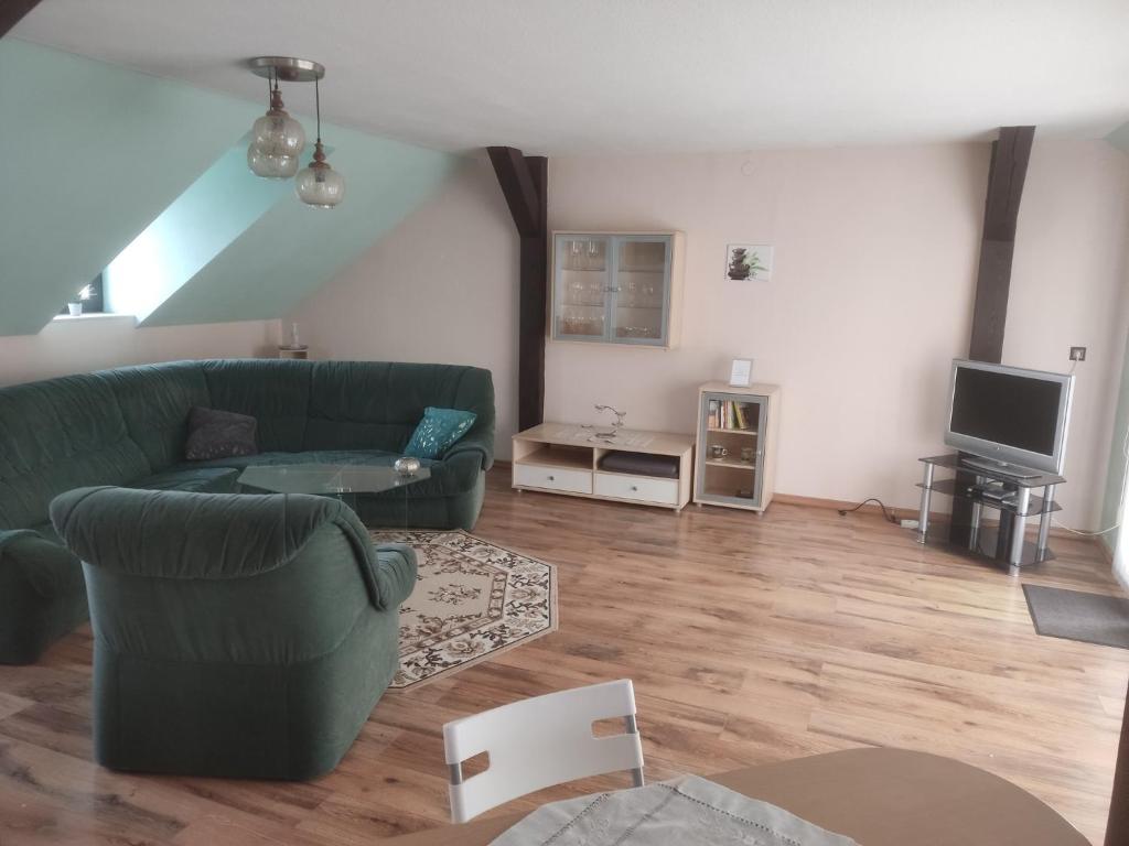 un soggiorno con divano verde e TV di Schöne 3,5 Zimmerwohnung a Peitz