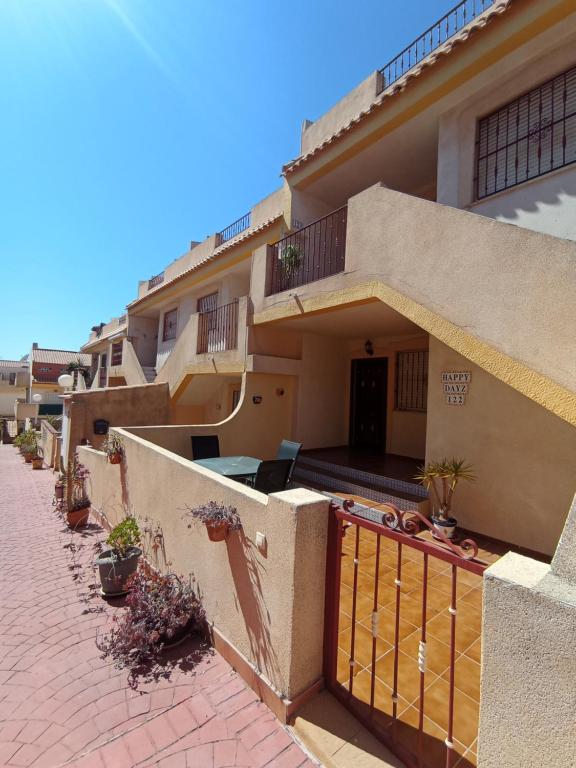 a house with a balcony and a brick sidewalk at Apartment in La Zenia in Orihuela Costa