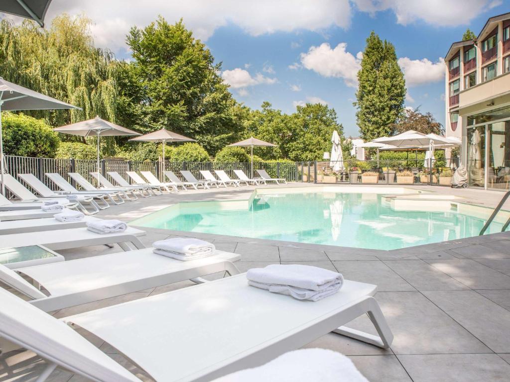 博恩的住宿－博恩中心美居酒店，一个带躺椅的游泳池和一个游泳池