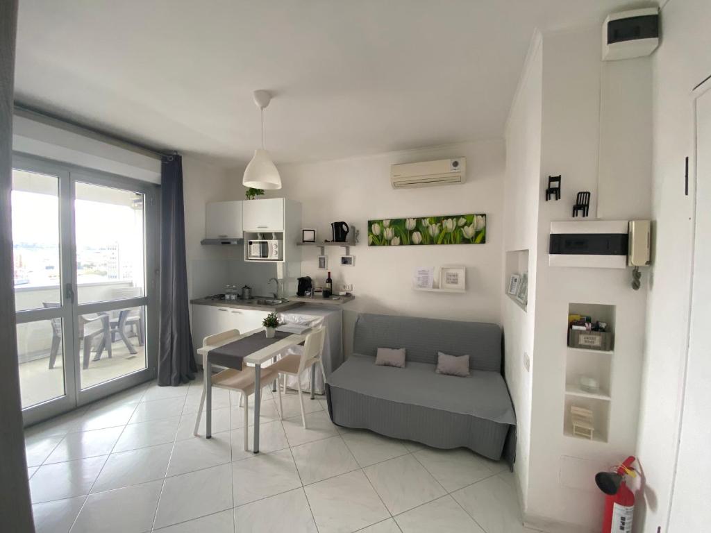 una cucina e un soggiorno con tavolo e divano di VESUCHARME Flat a Napoli