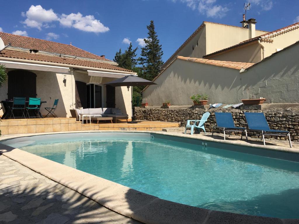 basen z dwoma krzesłami i dom w obiekcie Charmante villa en Petite Camargue w mieście Mus