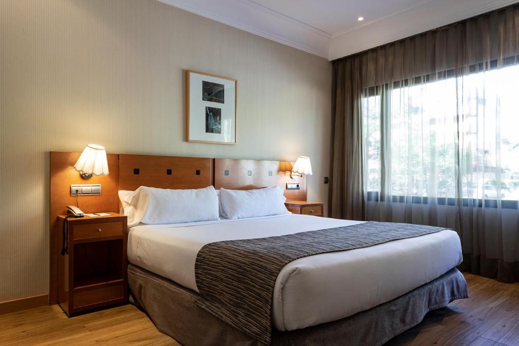 Habitación de hotel con cama grande y ventana en Petit Palace Arturo Soria Alcalá en Madrid