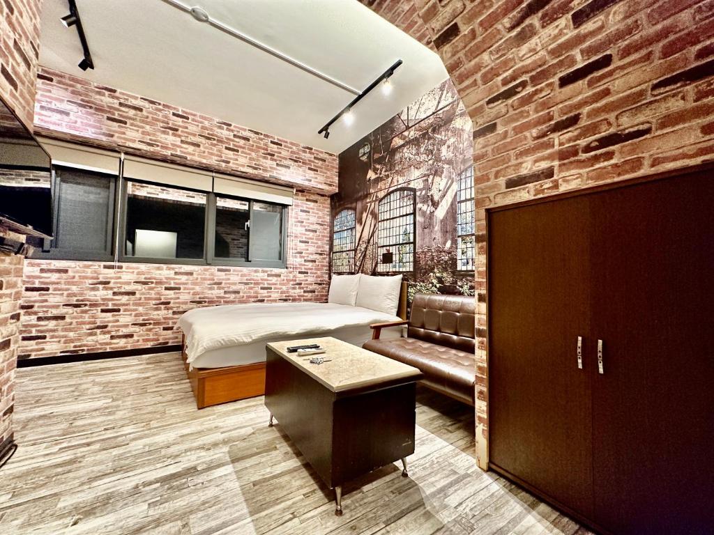 a bedroom with a bed and a brick wall at 御旅 Inn in Taichung