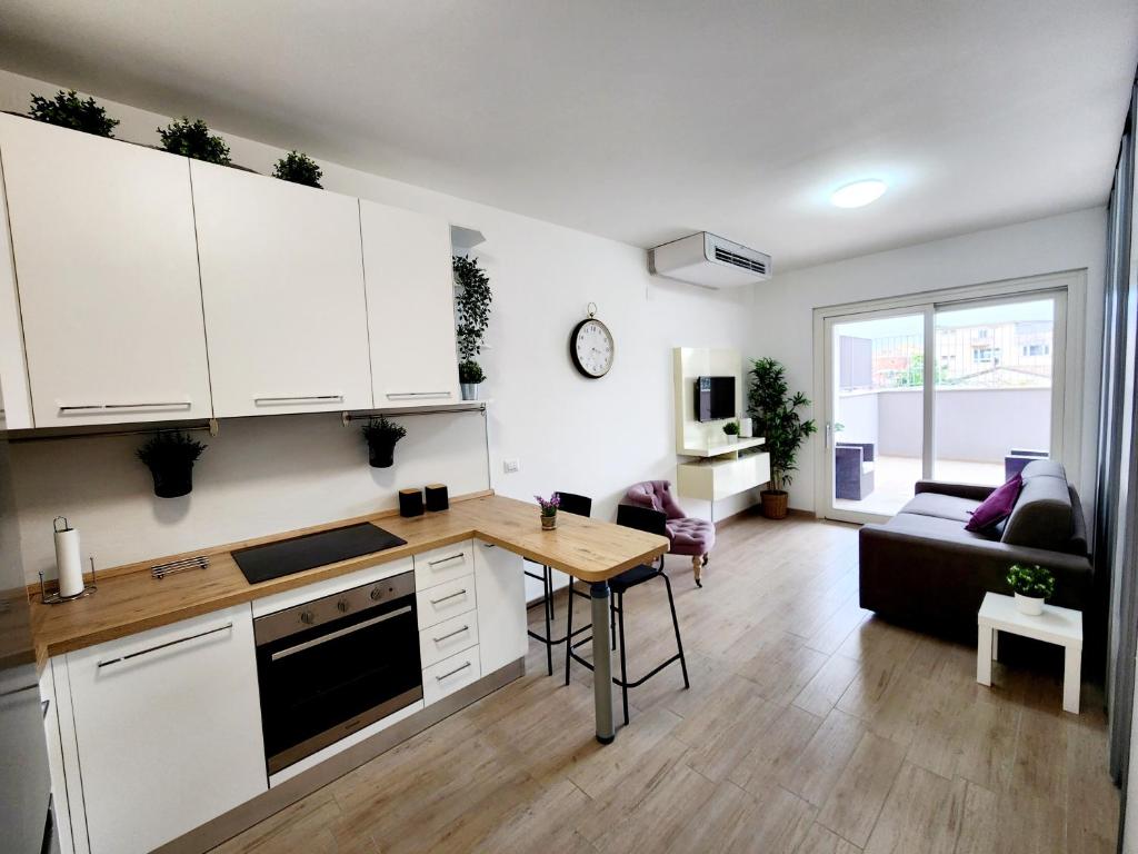 a kitchen and living room with white cabinets and a table at Quela Apartment - Pietralata in Rome