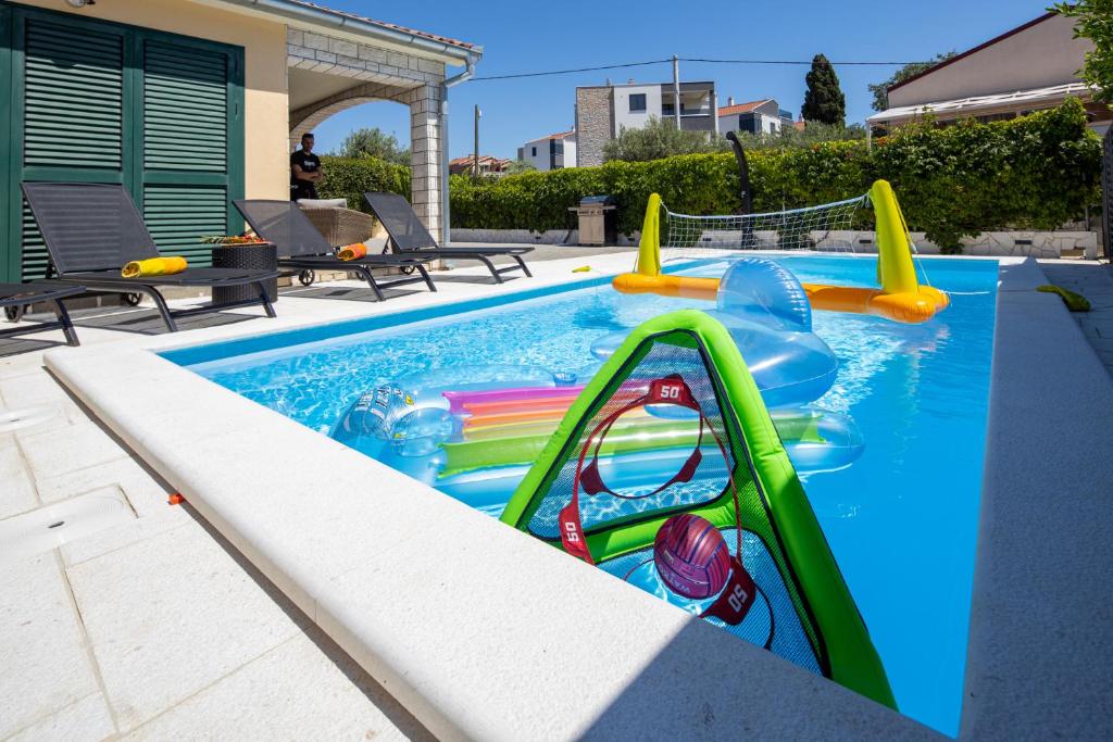 una piscina con un tobogán en un patio trasero en Villa a&a, en Biograd na Moru