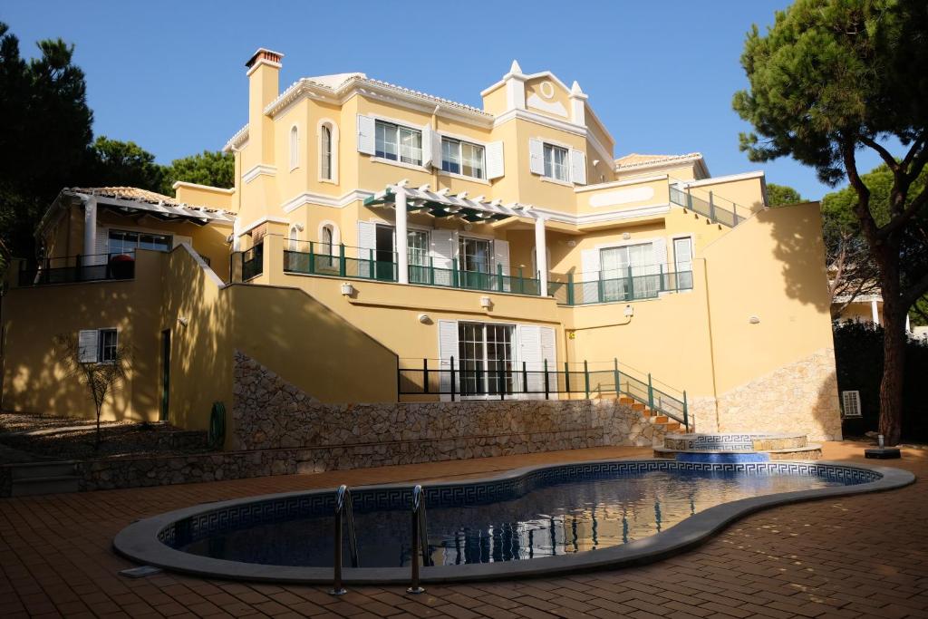 un bâtiment avec une piscine en face d'une maison dans l'établissement Praia Verde 130, à Castro Marim