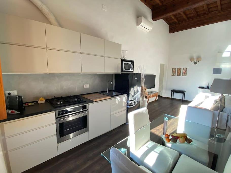uma cozinha com armários brancos e um forno com placa de fogão em Wonderful View Carmine em Florença