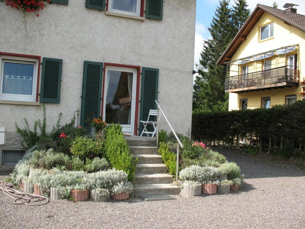 ein Haus mit Treppen und Blumen davor in der Unterkunft Haus Schwedes in Titisee-Neustadt