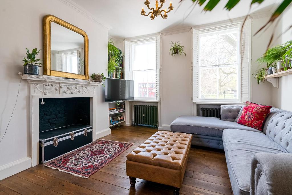 a living room with a couch and a fireplace at Historic 18th Century Terrace House in London