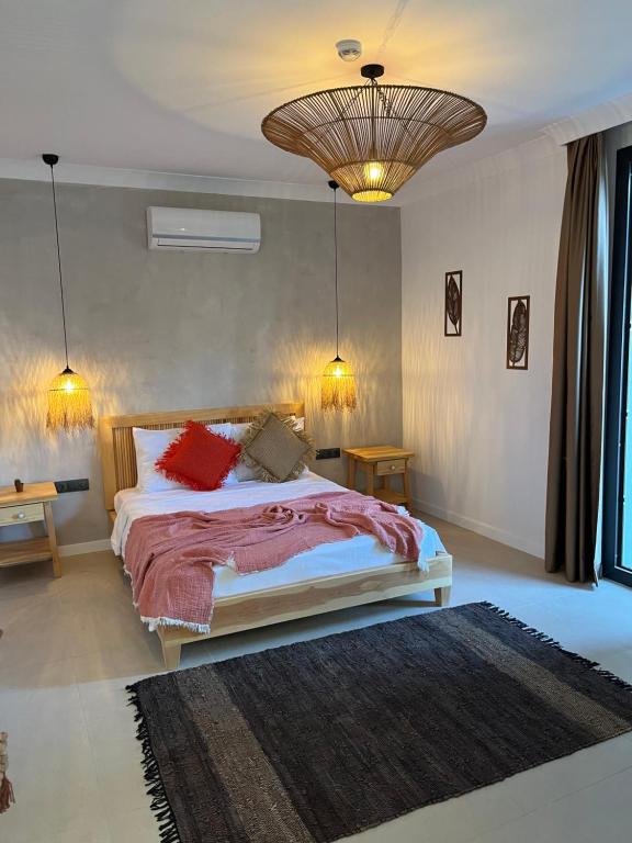 Un dormitorio con una cama con almohadas rojas. en LAGOM HOTEL, en Seferihisar