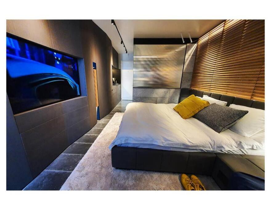 een slaapkamer met een groot bed en een tv aan de muur bij Luxury studio on Tlv w balcony on the sea in Jlil