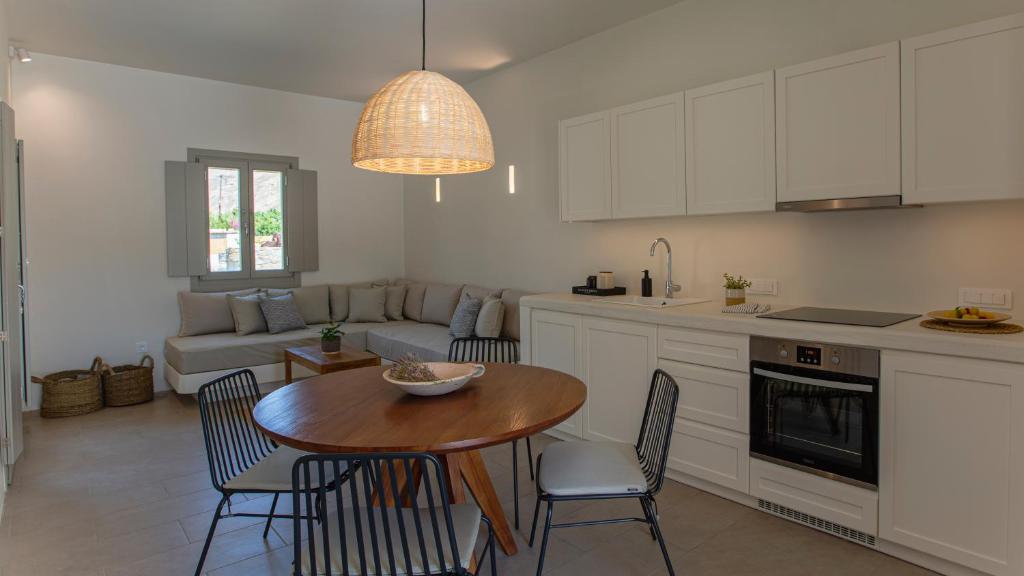 a kitchen and living room with a table and chairs at Kalami Suites in Livadi