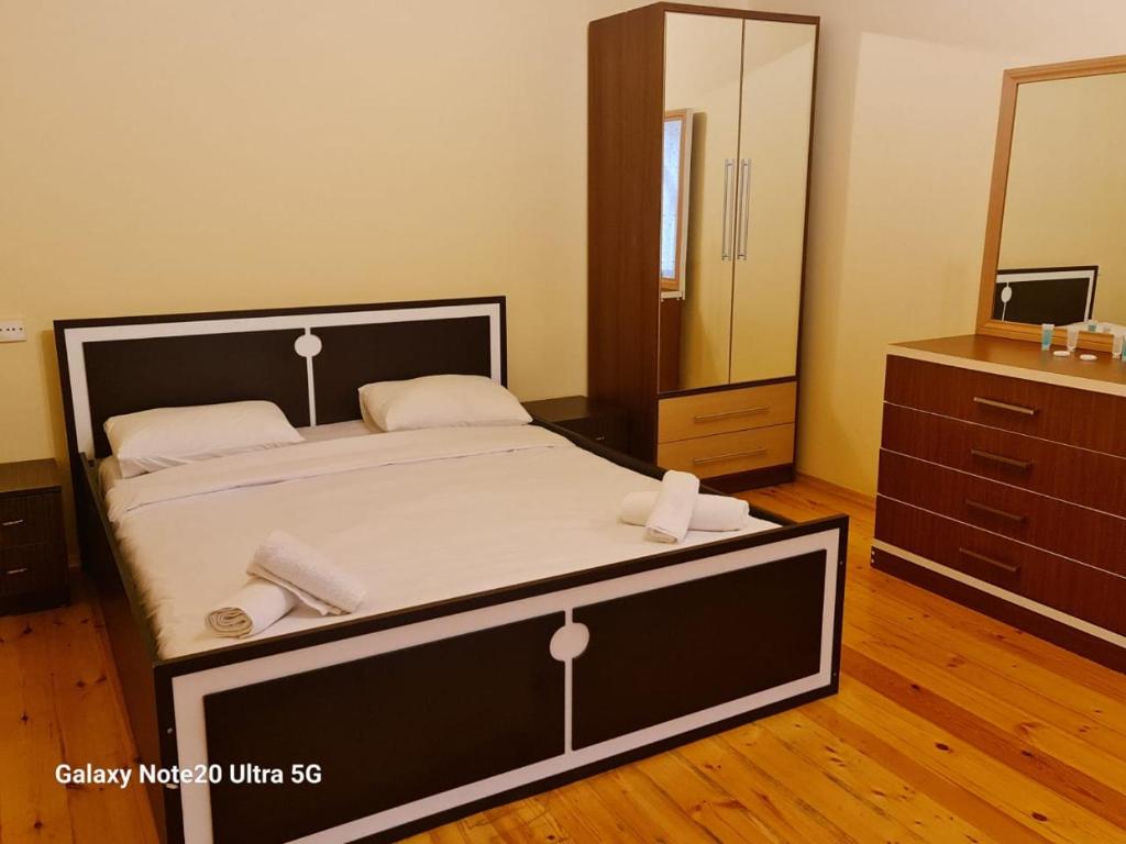 1 dormitorio con 1 cama grande y espejo en Rose House, en Sheki