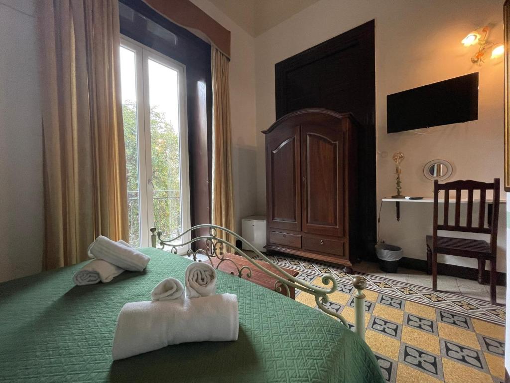 ein Schlafzimmer mit einem grünen Bett und Handtüchern darauf in der Unterkunft Teatro del Sole Cavour in Palermo
