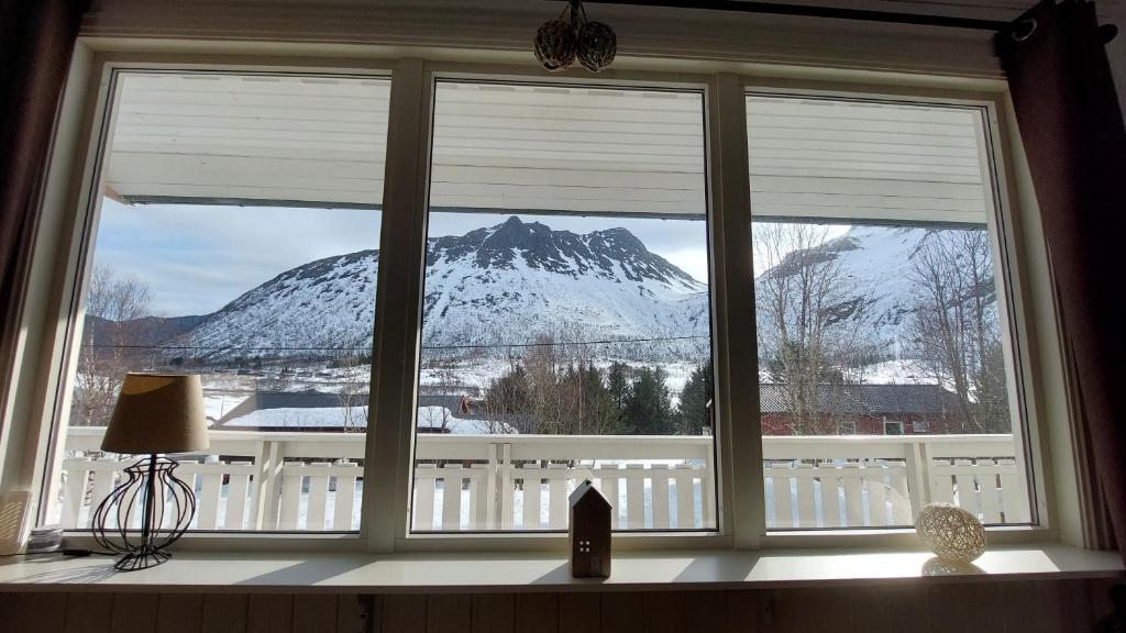 uma janela com vista para uma montanha coberta de neve em Holiday home on Senja em Grashopen