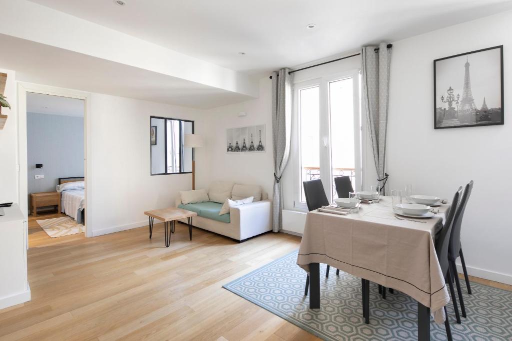 - un salon blanc avec une table et une salle à manger dans l'établissement Beaux 2-pièces Gare du Nord/Gare de l'Est, à Paris