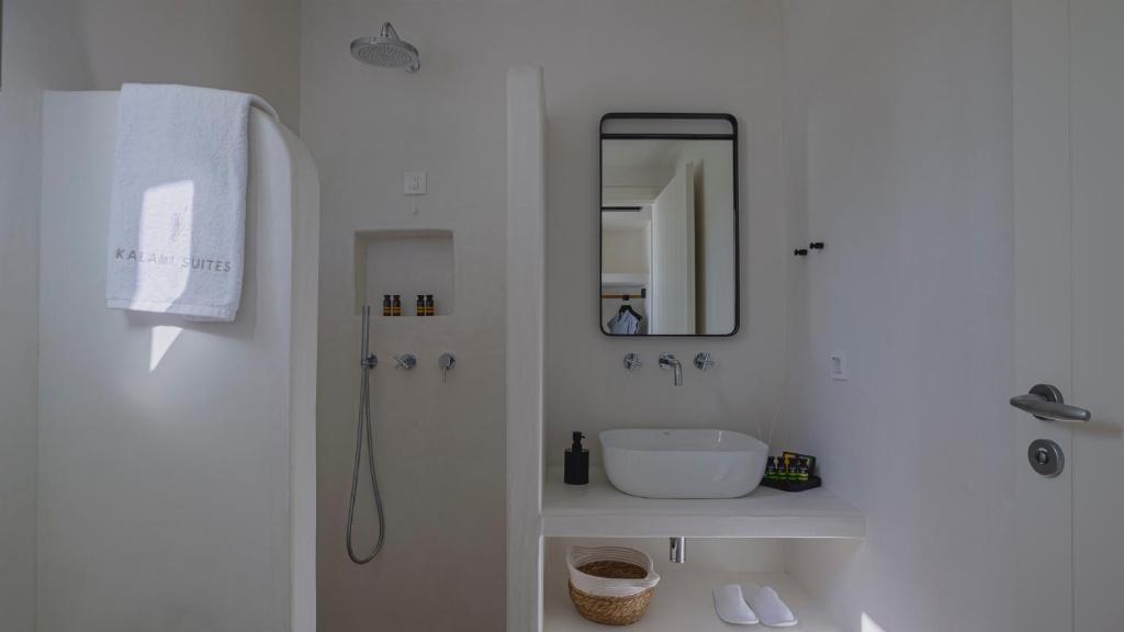 a white bathroom with a sink and a mirror at Kalami Suites in Livadi