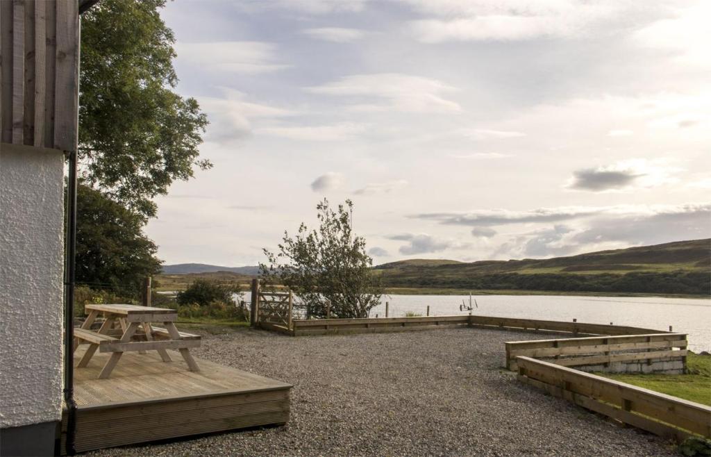 a picnic table next to a body of water at Taobh na Mara in Kensaleyre