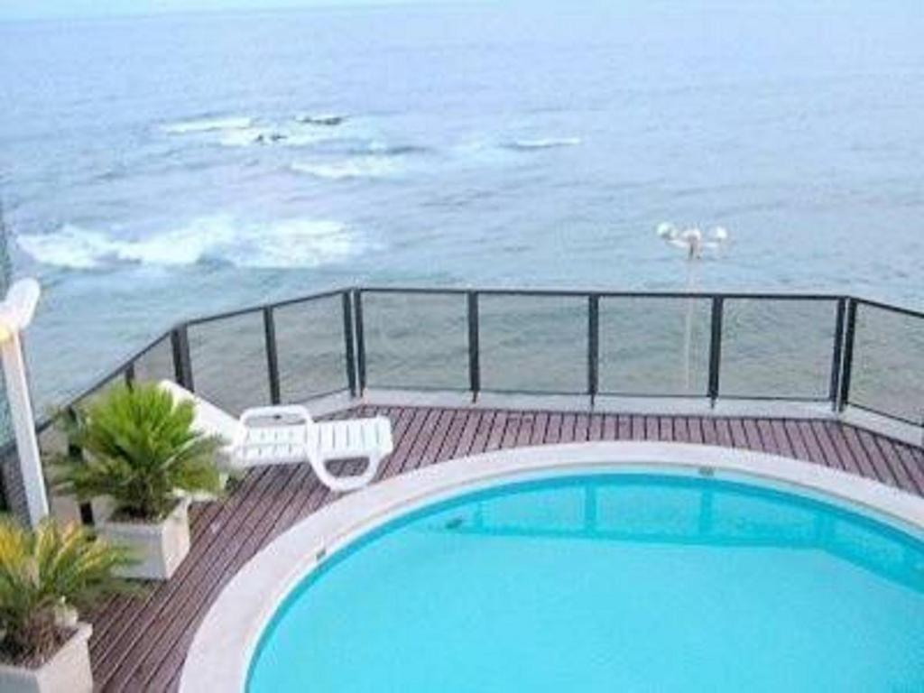 una piscina en una terraza junto al océano en Píer Sul Apart Hotel - Circuito do carnaval, en Salvador
