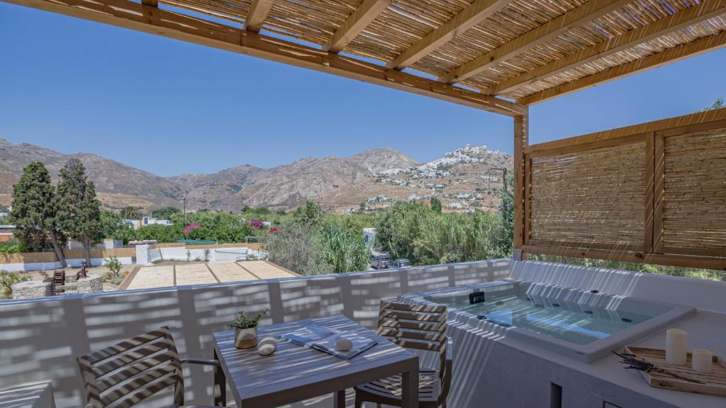 a patio with a table and a hot tub at Kalami Suites in Livadi