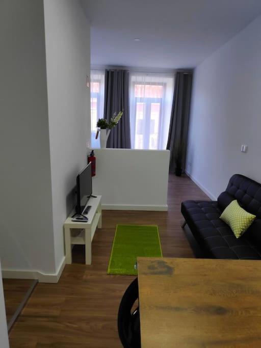 a living room with a couch and a flat screen tv at Pérola do Ar - Estúdio no coração de Setúbal in Setúbal