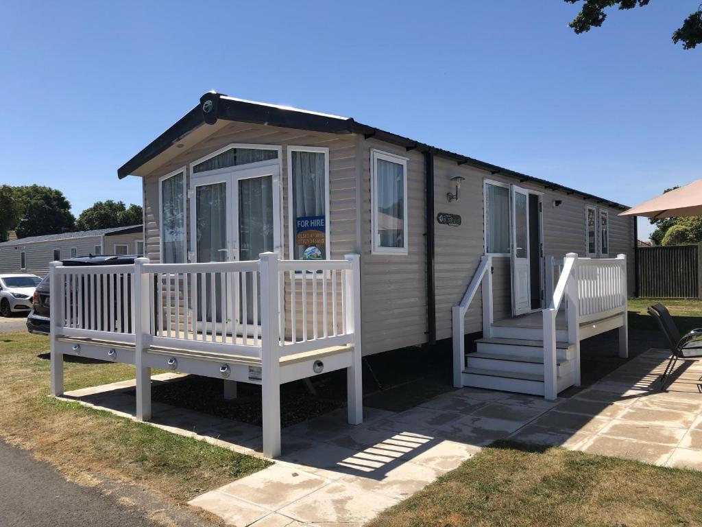 a tiny house with a staircase and a porch at Beautiful Caravan For To Hire At Hopton Haven Park In Norfolk Ref 80027t in Great Yarmouth