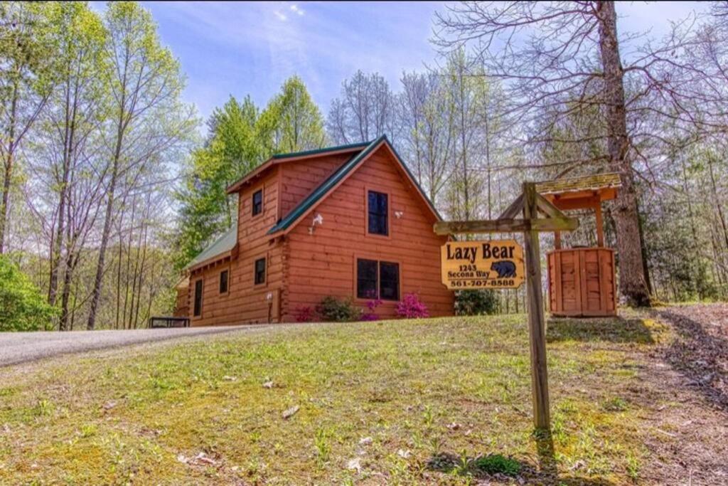 a log cabin with a sign in front of it at Lazy Bear Cabin in Sevierville