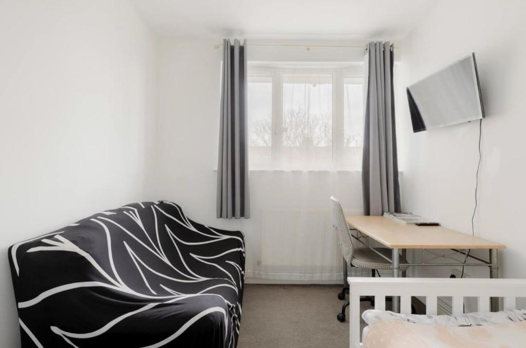 a room with a chair and a desk and a window at The Lovely Room in London