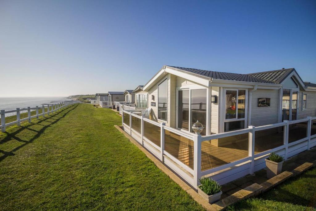 a house on the side of the beach at Luxury Lodge With Stunning Sea Views At Hopton Haven Park Ref 80055s in Great Yarmouth