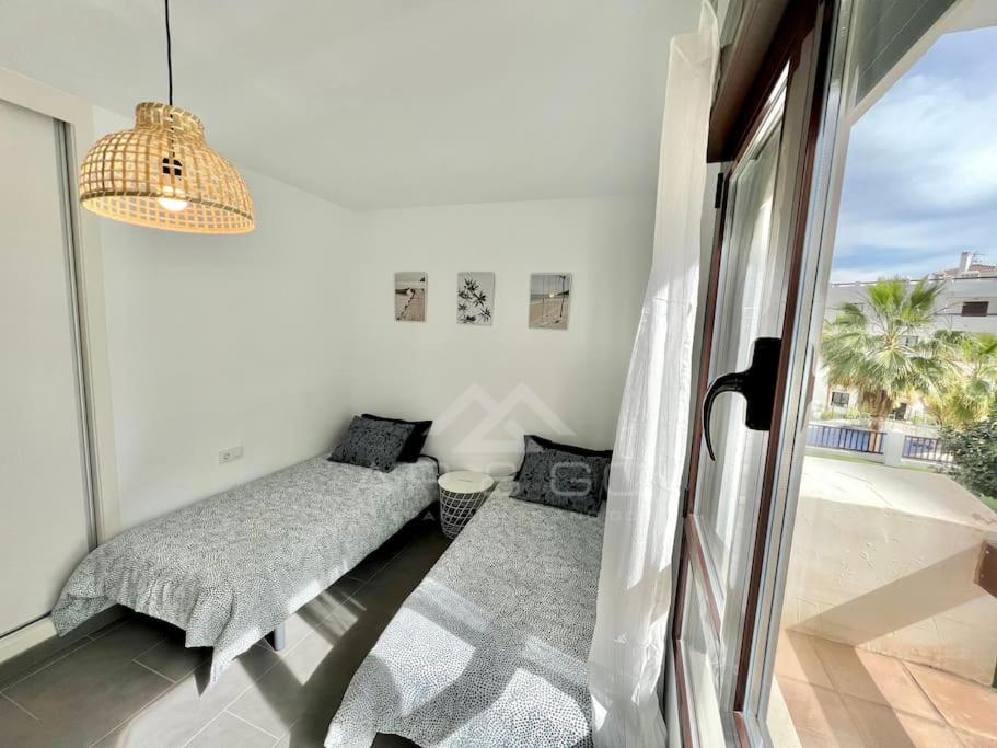 sypialnia z łóżkiem i oknem z widokiem w obiekcie Oasis & Spa Apartment w mieście Salobreña