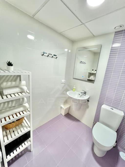 Łazienka z białą toaletą i umywalką w obiekcie Oasis & Spa Apartment w mieście Salobreña