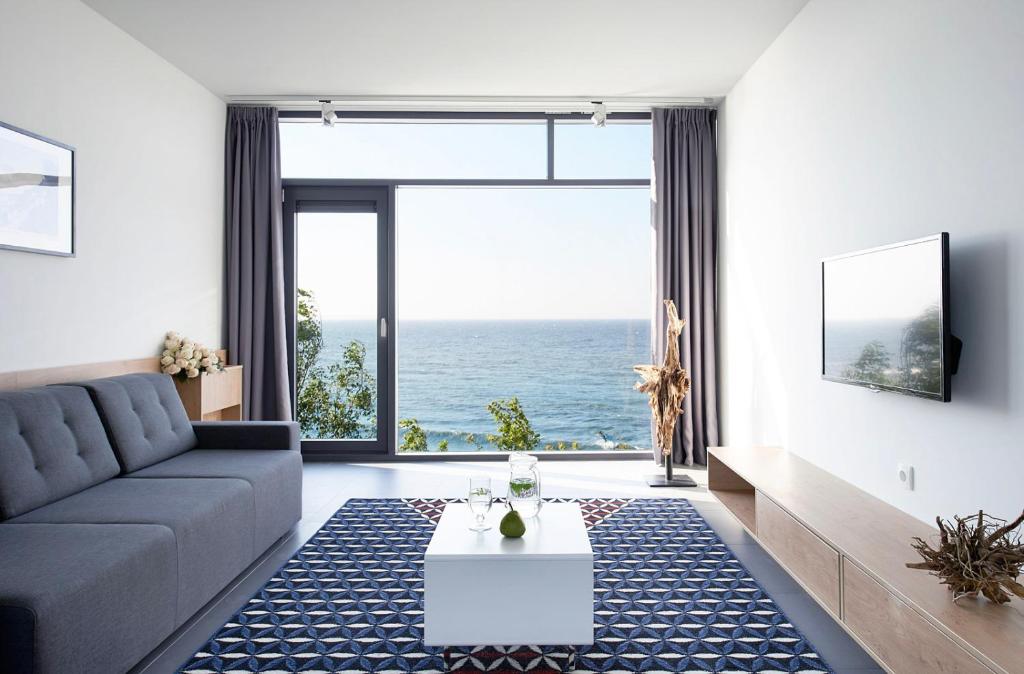 a living room with a couch and a view of the ocean at Boulevard Ustronie Morskie by Zdrojowa in Ustronie Morskie