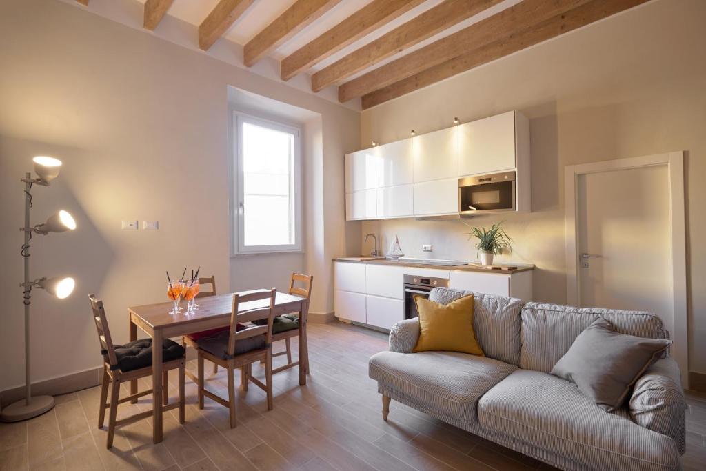 een woonkamer met een bank en een tafel en een keuken bij Green Coast House 3 in Piombino