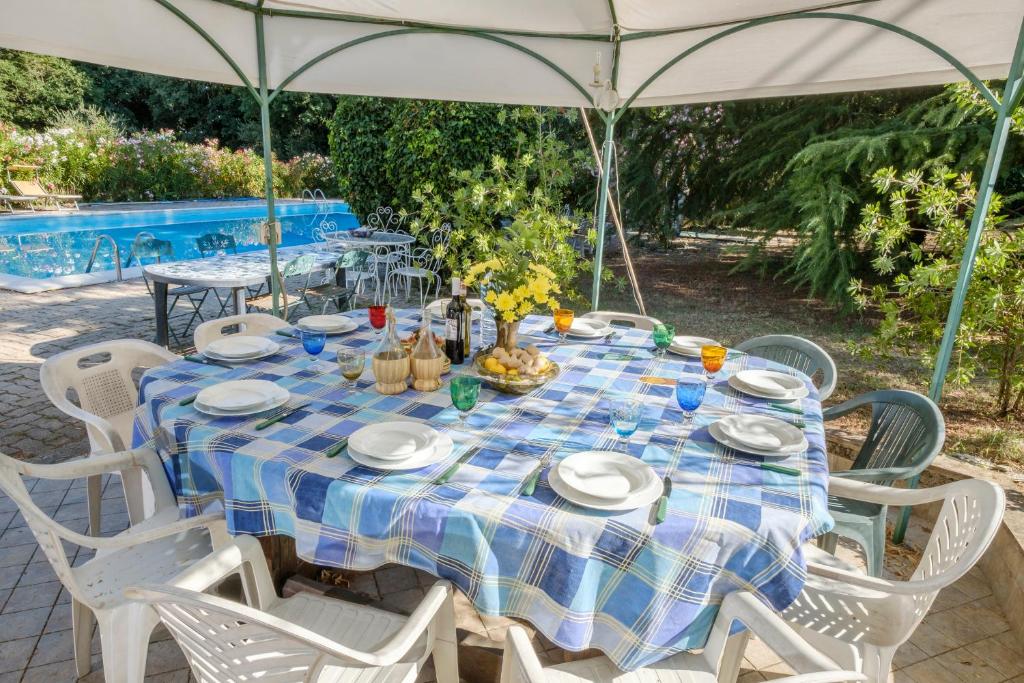 mesa con sillas blancas y mantel azul y blanco en Umbria Country B&B, en Giove