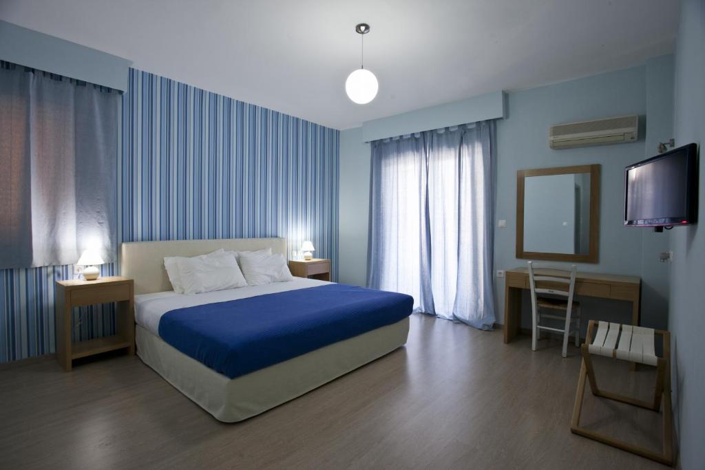Dormitorio azul con cama y TV en Valente Perlia Rooms en Poros