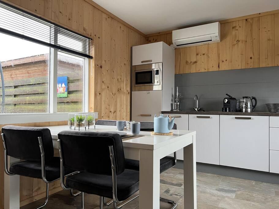 a kitchen with a table and chairs in a kitchen at Sunny view Egmond in Egmond-Binnen