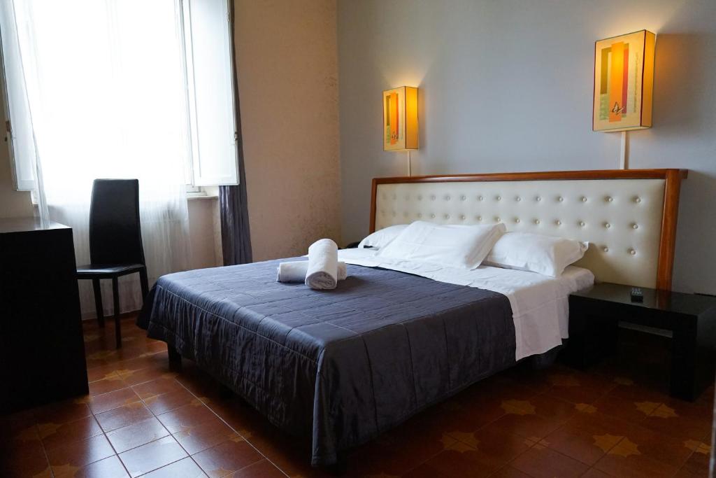a bedroom with a bed with a stuffed animal on it at Roma Room Hotel in Rome