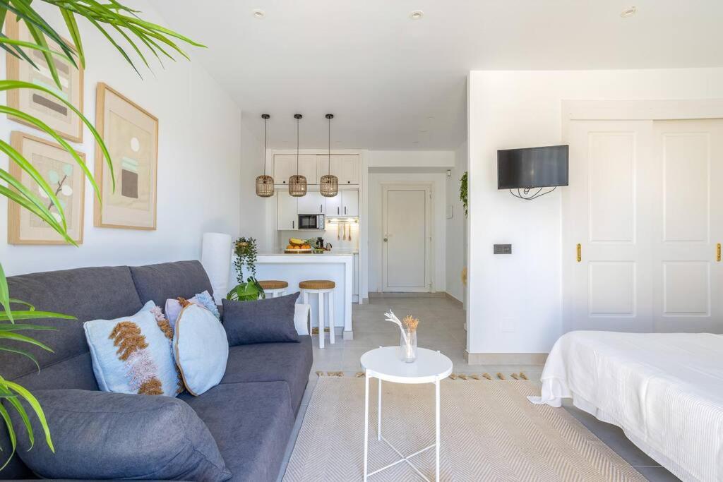 un soggiorno con un divano blu e una cucina di OleHolidays 726 Romana Playa junto al mar a Marbella