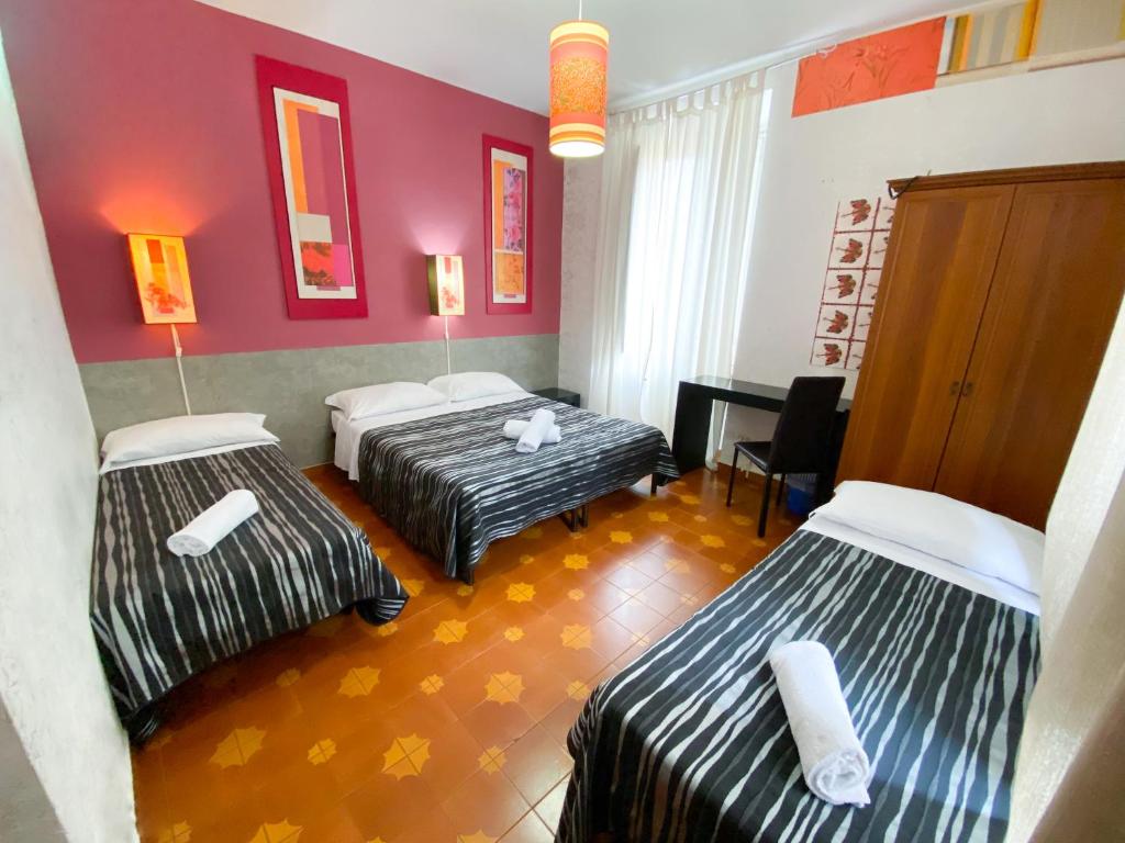 a hotel room with three beds and a piano at Roma Room Hotel in Rome
