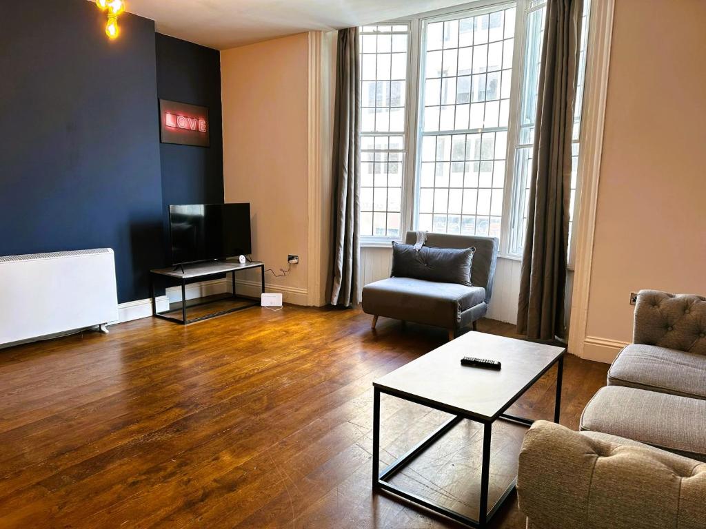 a living room with a couch and a tv at Central Brighton location I One Bedroom Flat in Brighton & Hove