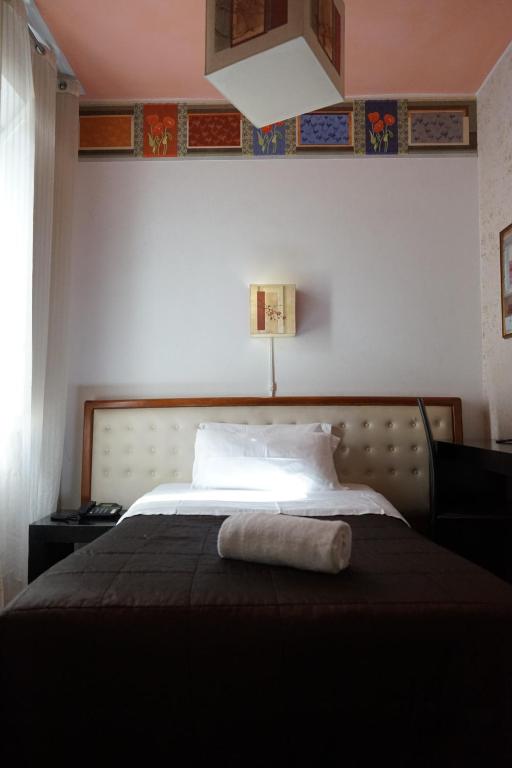 a bedroom with a bed with a towel on it at Roma Room Hotel in Rome