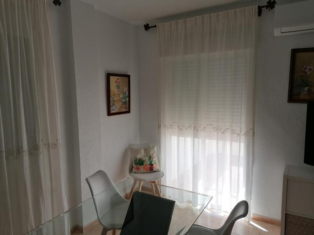 une chambre avec une table et des chaises en verre ainsi qu'une fenêtre dans l'établissement Alojamiento las Dunas, à Tabernas