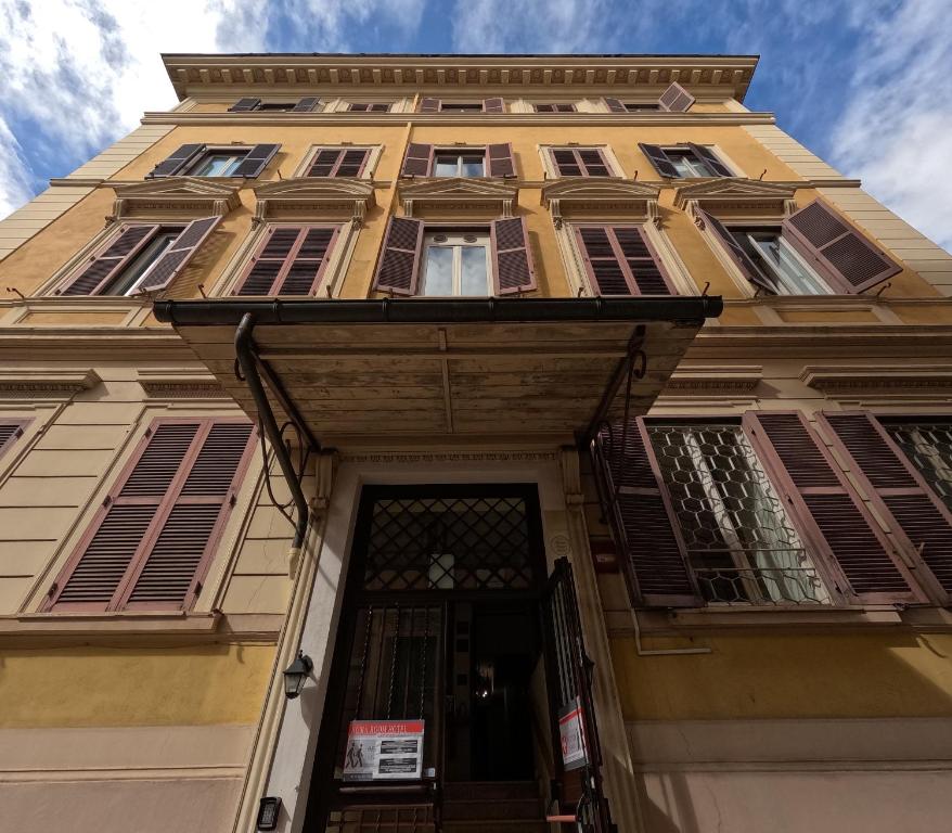 a tall yellow building with a door at Roma Room Hotel in Rome