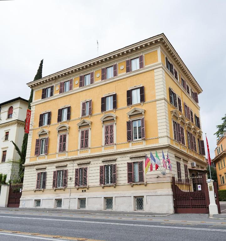 a large yellow building on the side of a street at Roma Room Hotel in Rome