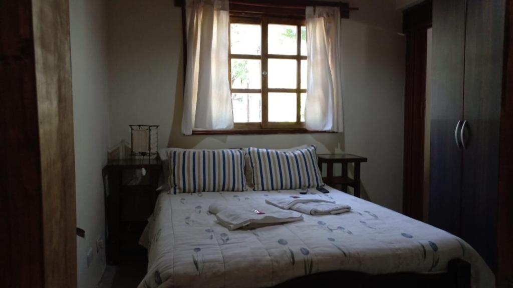 a bedroom with a bed with a window and towels on it at el remanso in San Agustín de Valle Fértil