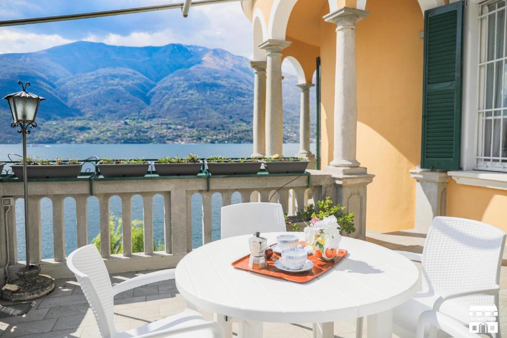 Villa Plinio Lago di Como في ديرفيو: طاولة وكراسي على شرفة مطلة على الجبال