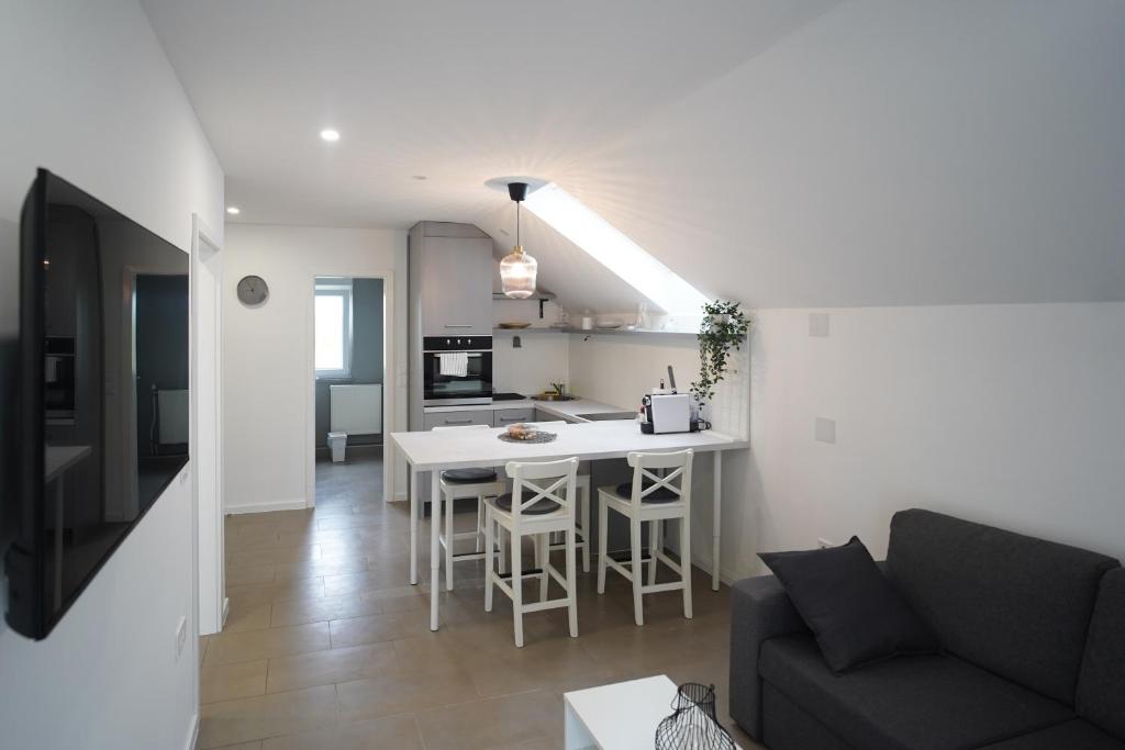 Apartments Choice في فيليكا غوريكا: غرفة معيشة ومطبخ مع أريكة وطاولة