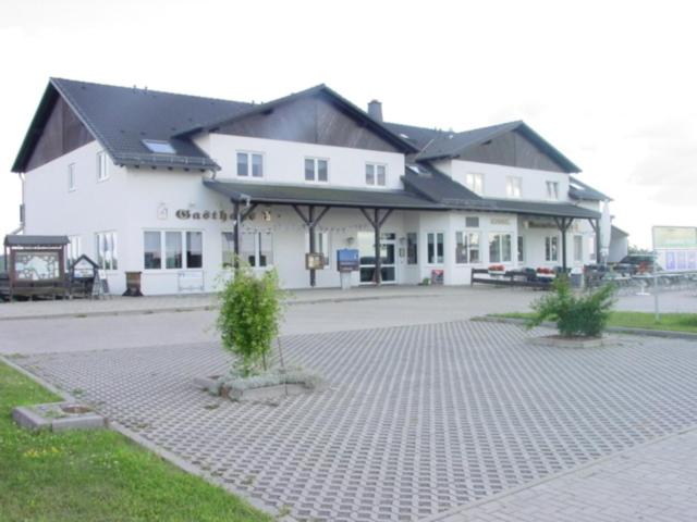 a large white building with a courtyard in front of it at Hotel und Gasthaus Rammelburg-Blick in Friesdorf